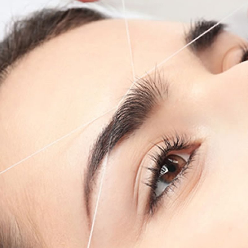 Close up eyebrow threading treatment showing the process in East Grinstead